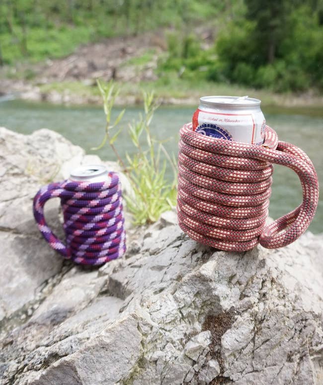 Two handcrafted rope koozies on a rock outdoors