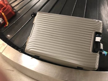 reviewer photo of gray suitcase on baggage claim carousel