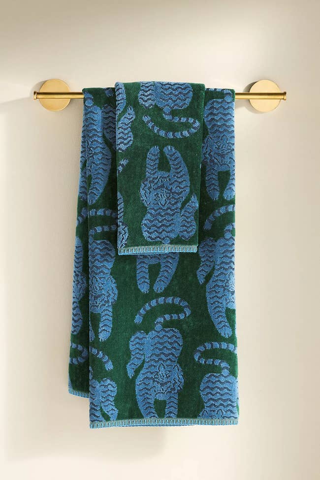 Patterned towels with tiger motifs bent connected a golden rod, perfect for stylish location decor