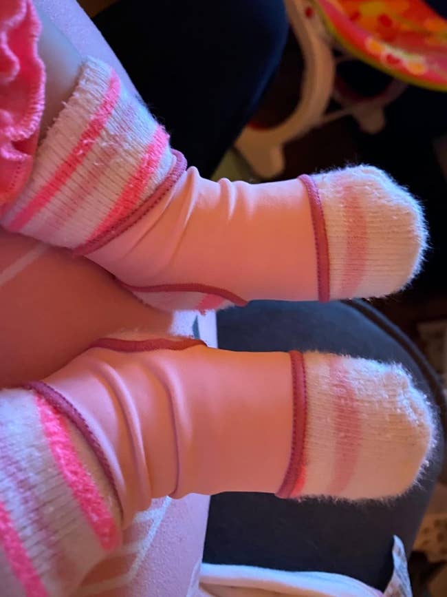 reviewer photo of the pink sleeve over a baby's socks