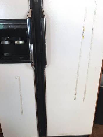 reviewer's fridge before, with stripes of adhesive residue on the front
