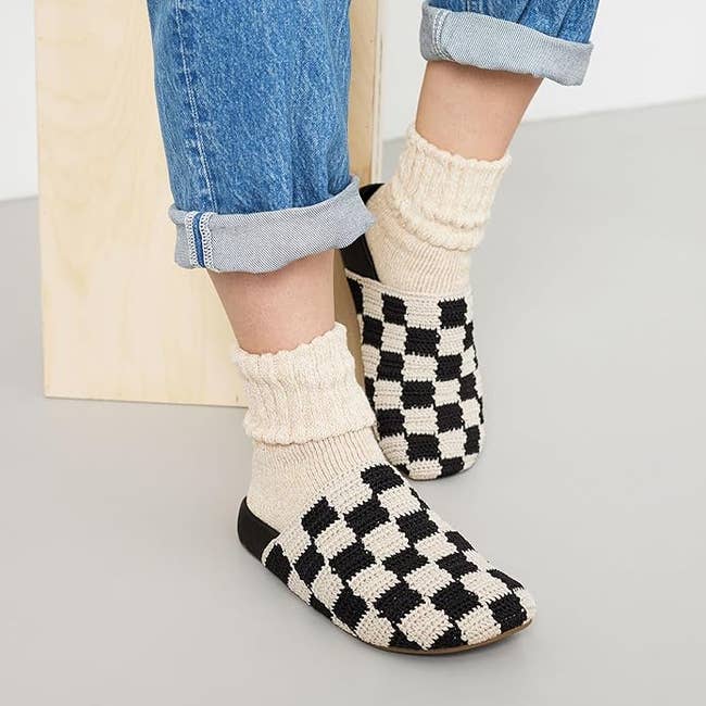 model wearing the black and cream checkered clogs