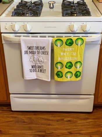 a reviewer's stove with a white kitchen towel on it that says sweet dreams are made of cheese who I am to dis a brie?