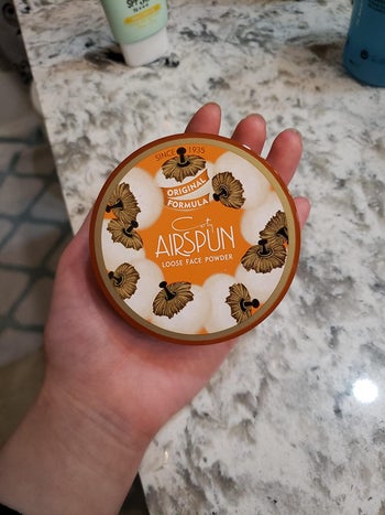 Reviewer holding powder in their hand