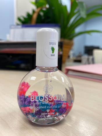Bottle of Blossom scented cuticle oil with real flowers inside