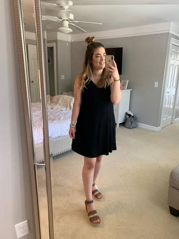 Person successful  a elemental  formal  and sandals takes a reflector  selfie successful  a cozy bedroom, showcasing a casual outfit suitable for summertime  shopping