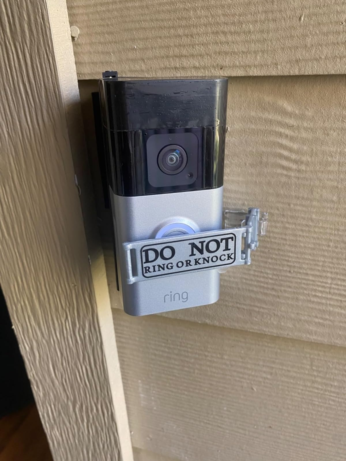 Kamera bel pintu dengan tanda bertuliskan, 