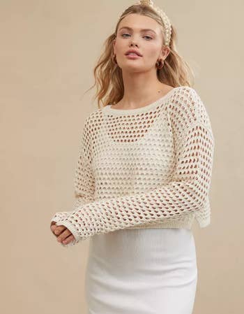 Model wearing a white knit sweater with a textured pattern