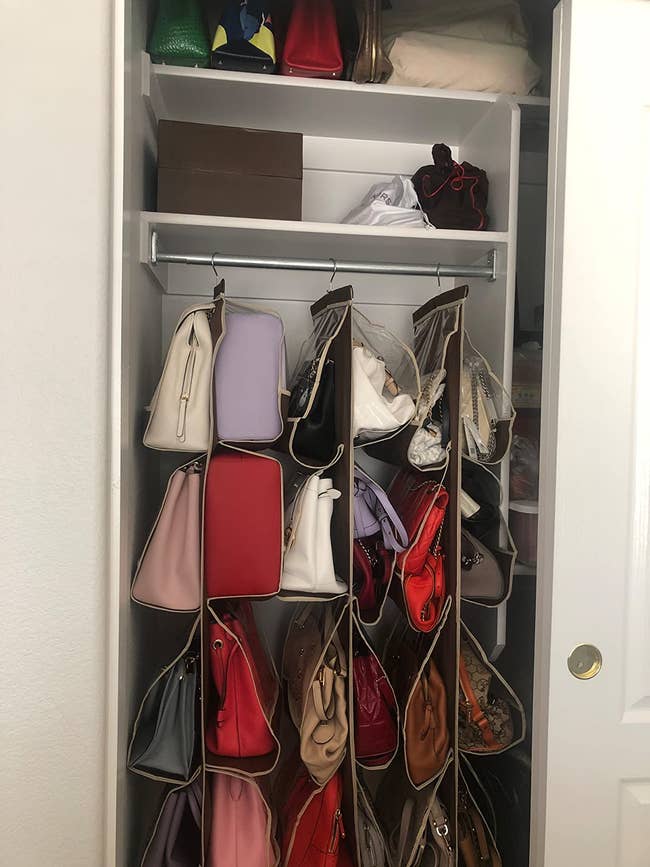 Three purse closet organizers hanging in a closet filled with purses