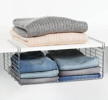 Folded clothes placed on shelf and in attached hanging basket