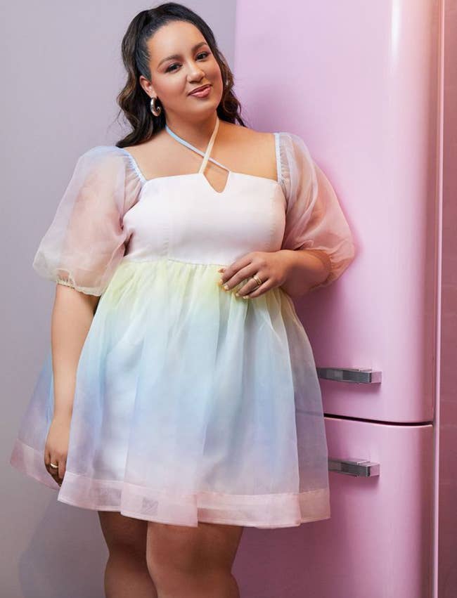 a model i a short rainbow pastel ombre dress with puffy organza sleeves