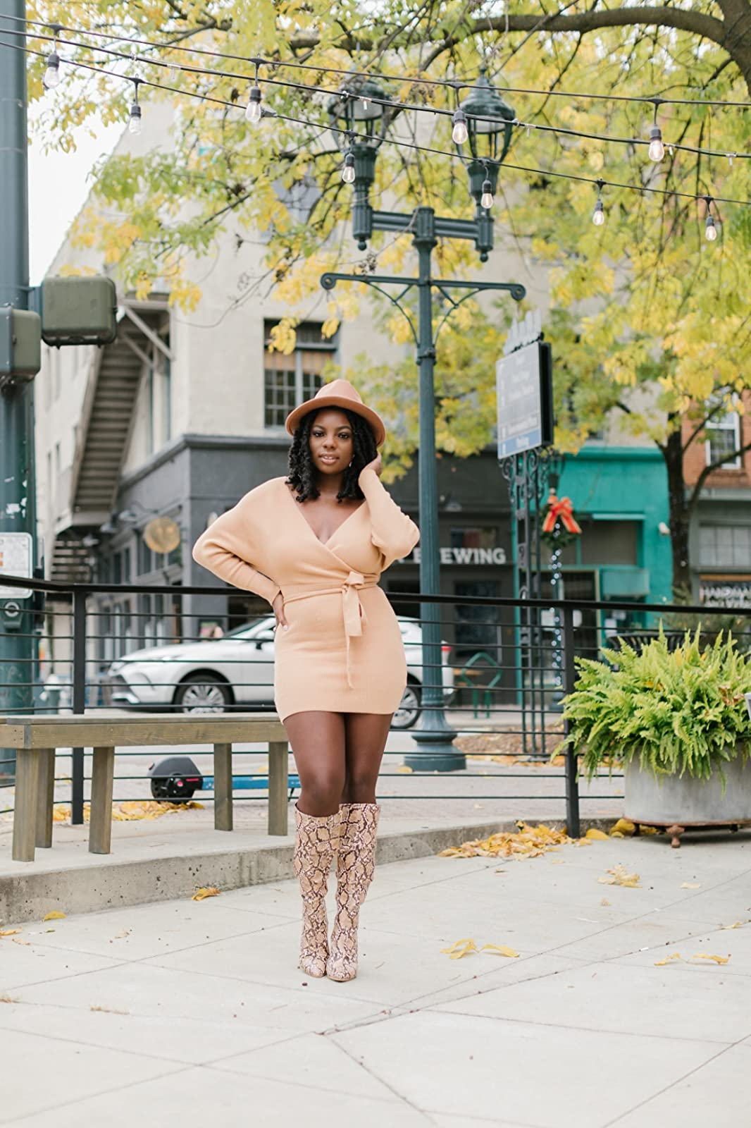 reviewer wearing the tan formal  with knee-high boots and a hat
