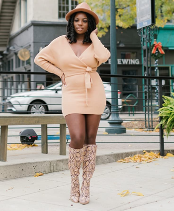 reviewer wearing the tan dress with knee-high boots and a hat