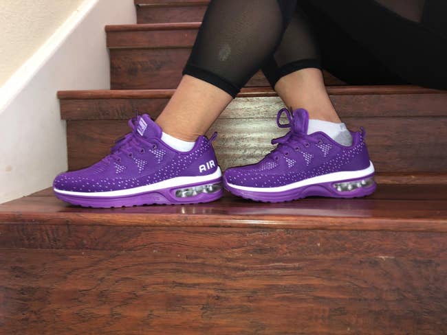 Reviewer show side view of purple STQ running shoes