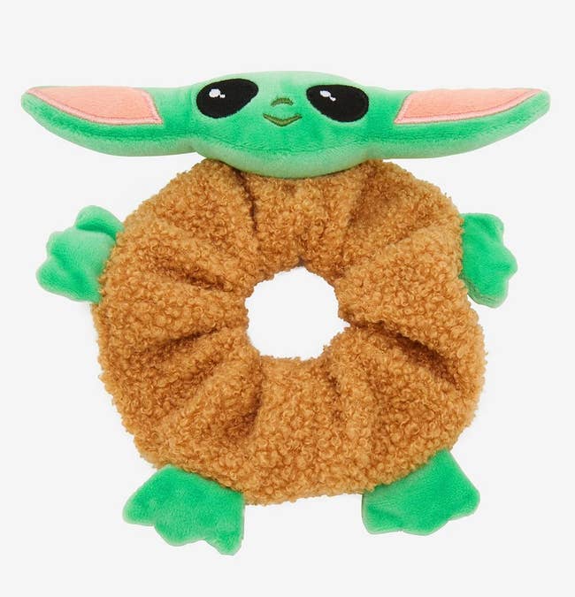 brown fuzzy scrunchie with green grogu face arms and legs