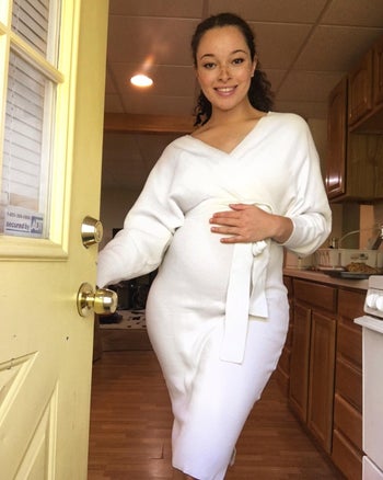 reviewer photo wearing the dress in white, holding pregnancy bump