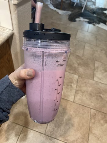 reviewer showing a pink smoothie they made with the blender