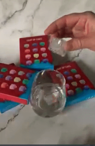 GIF of reviewer putting flashing cubes in a wine glass 