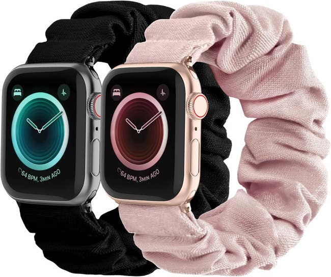 Two smartwatches with black straps next to a pink fabric watchband accessory