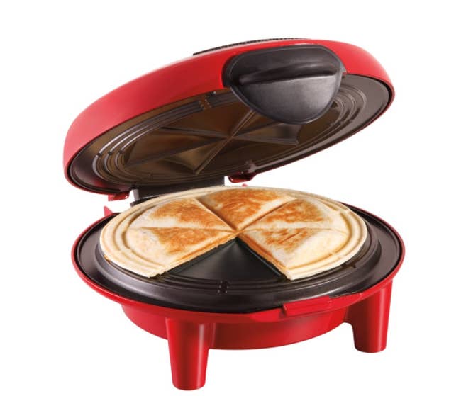 A red quesadilla maker with quesadillas in the middle