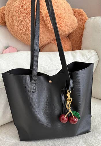 Black tote container with cherry charm connected sofa; ample teddy carnivore and cushion backdrop