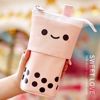 Model holding a pencil case shaped like a bubble tea 