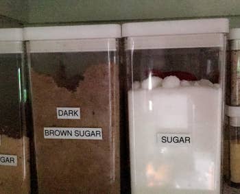 reviewer photo of three canisters filled with different types of sugar, which have been labeled using the label maker