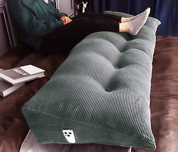 the pillow being used to lift up a person's legs