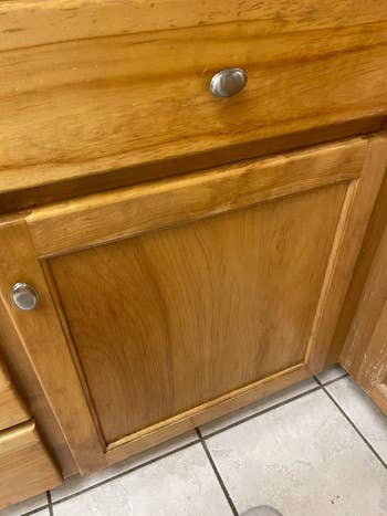 Wooden room furniture with rounded metallic knobs, shown closed implicit a tiled floor
