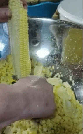 gif of reviewer using the peeler to remove kernels from an ear of corn