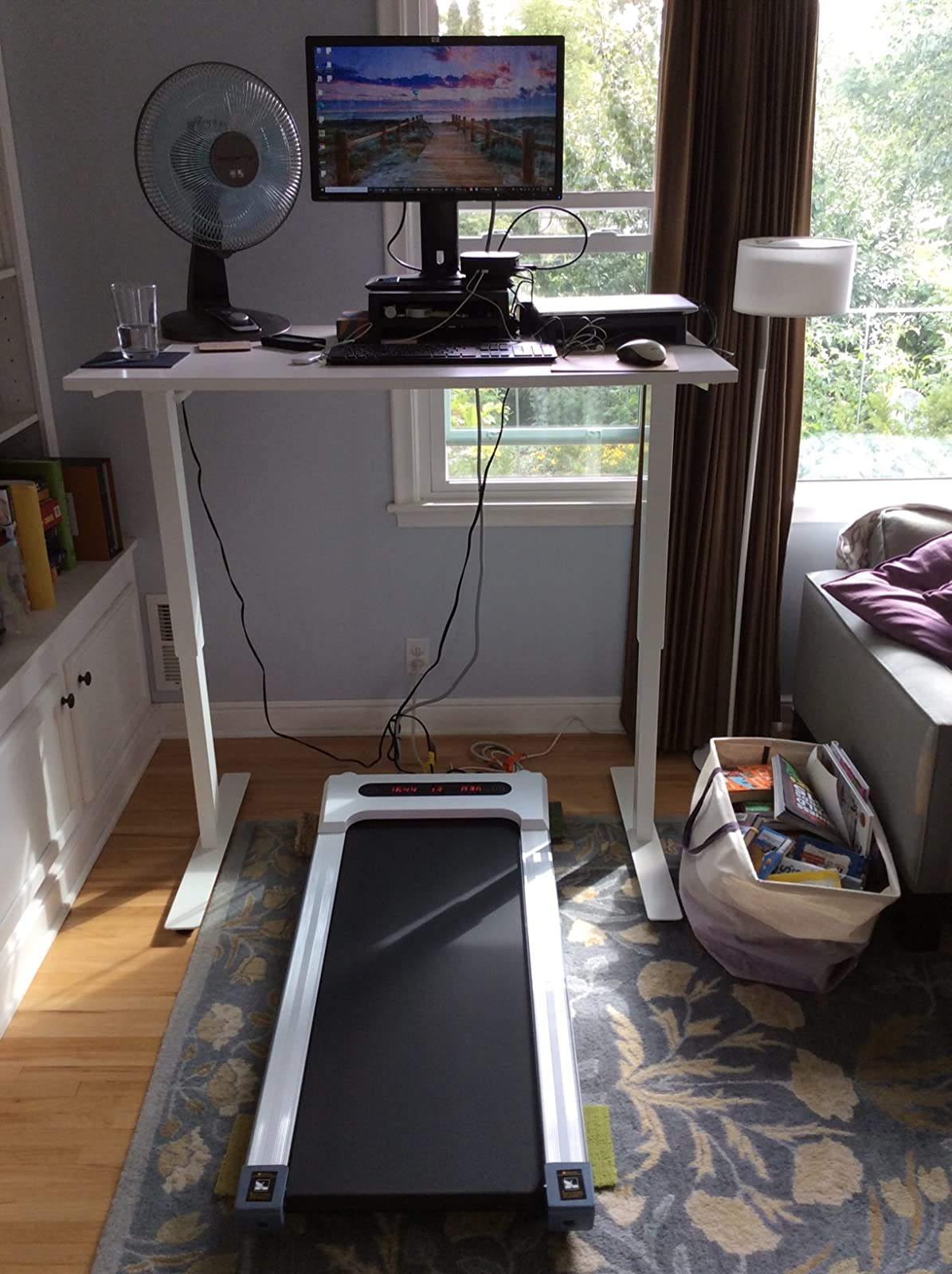 the white treadmill under a reviewer's standing desk setup