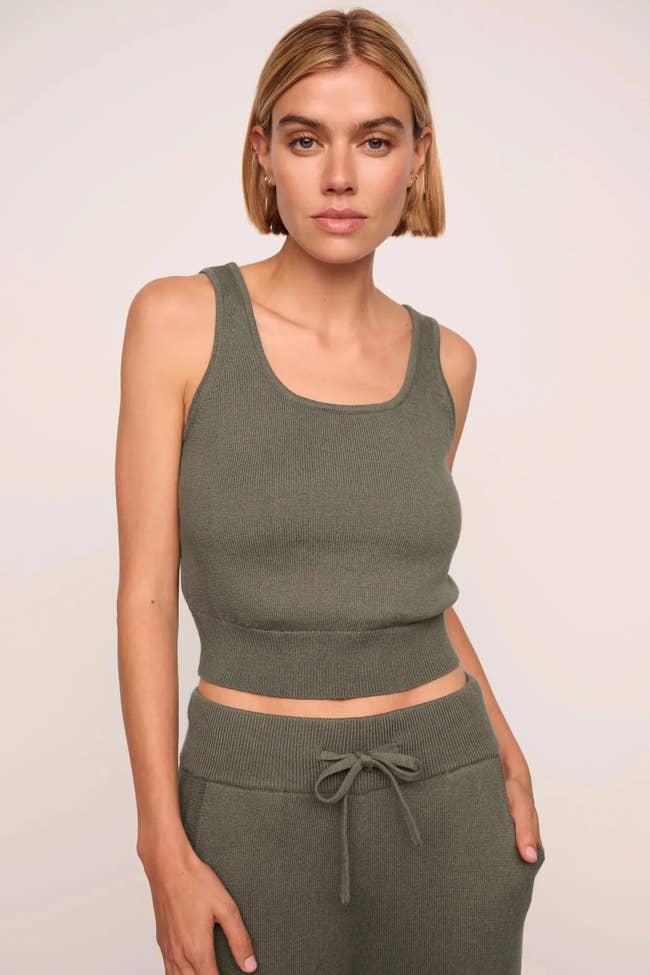 Person modeling a sleeveless knit vessel  apical  with matching high-waisted drawstring pants successful  a neutral tone