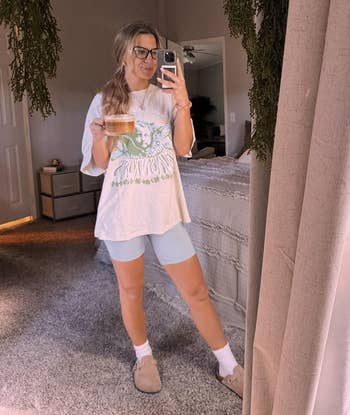 reviewer taking a reflector selfie wearing cozy apparel and the shoes with socks