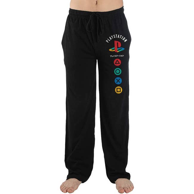 a model wearing black lounge pants with playstation logo and buttons on the side