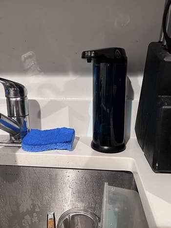 A reviewer's black soap dispenser on their sink
