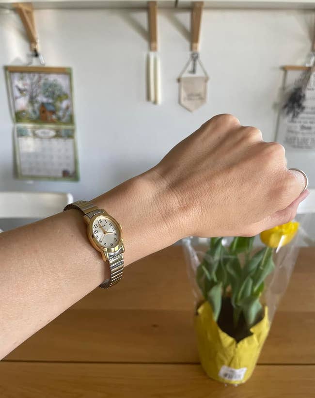 reviewer wearing the silver tone watch on their wrist