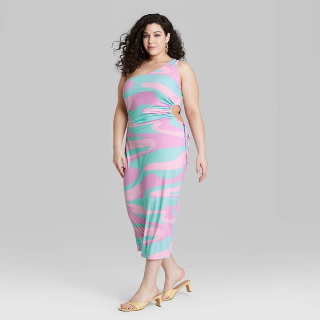 model wearing one-shoulder dress with side cut out in blue and pink swirl pattern