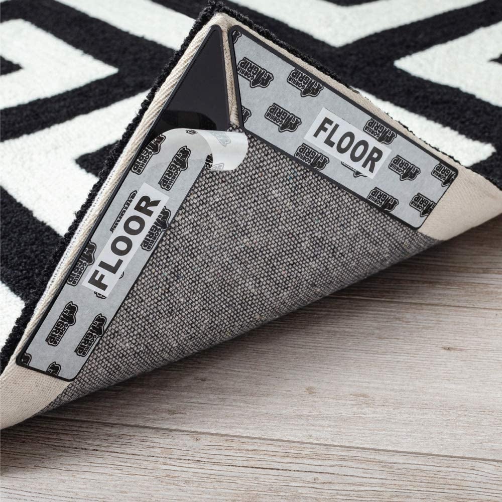 Two pieces of black grip tape on corner of the underside of a rug