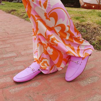 model wearing bright purple mules with floral wide-leg pants
