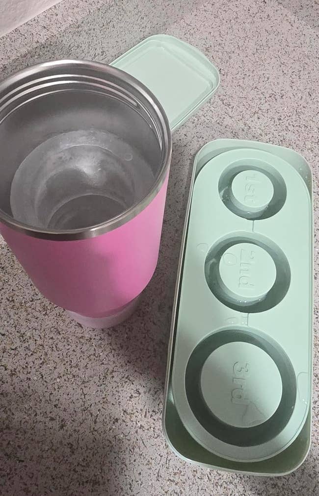 Pink tumbler and green ice cube tray with labeled compartments (