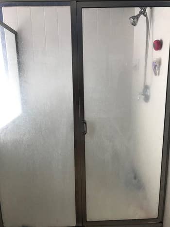 before reviewer image of a cloudy and stained shower door