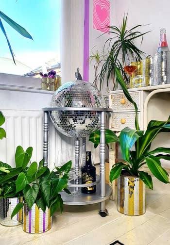The silver colored bar cart with a silver disco ball