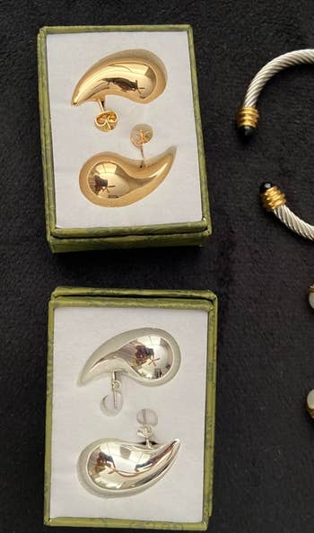 two pairs of the reviewer's earrings in the boxes in gold and in silver