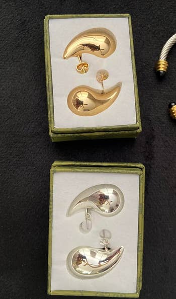 two pairs of the reviewer's earrings in the boxes in gold and in silver