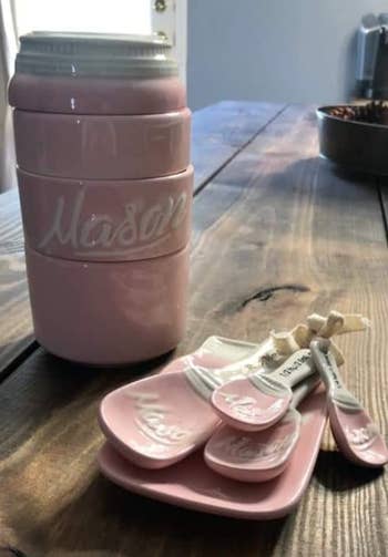 the light pink mason jar themed stackable cups, spoons, and spoon rest on a counter 
