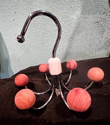 Metal hook with woody  ball-capped arms, resembling an octopus, perfect  for organizing accessories oregon  bags. 