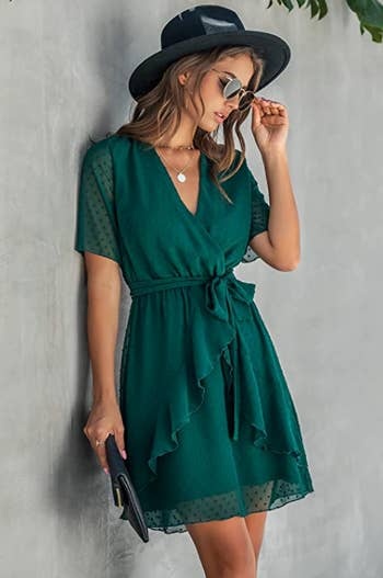 a model in a forest green dress with short sleeves and a ruffle in the middle