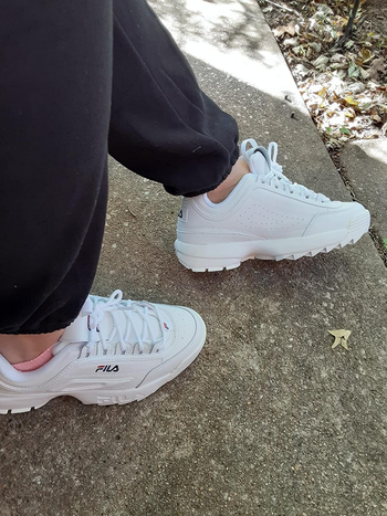 Reviewer wearing the chunky white sneakers with grey joggers