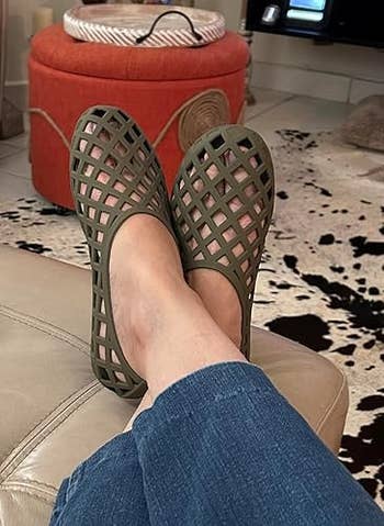 Person wearing stylish, lattice-designed slip-on shoes portion relaxing, suggesting comfortableness and casual fashion