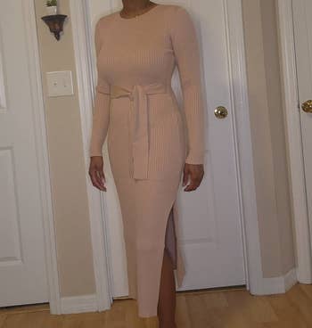 Person wearing a fitted, ribbed knit formal with agelong sleeves and a mid-length hem, highlighted by a waist tie